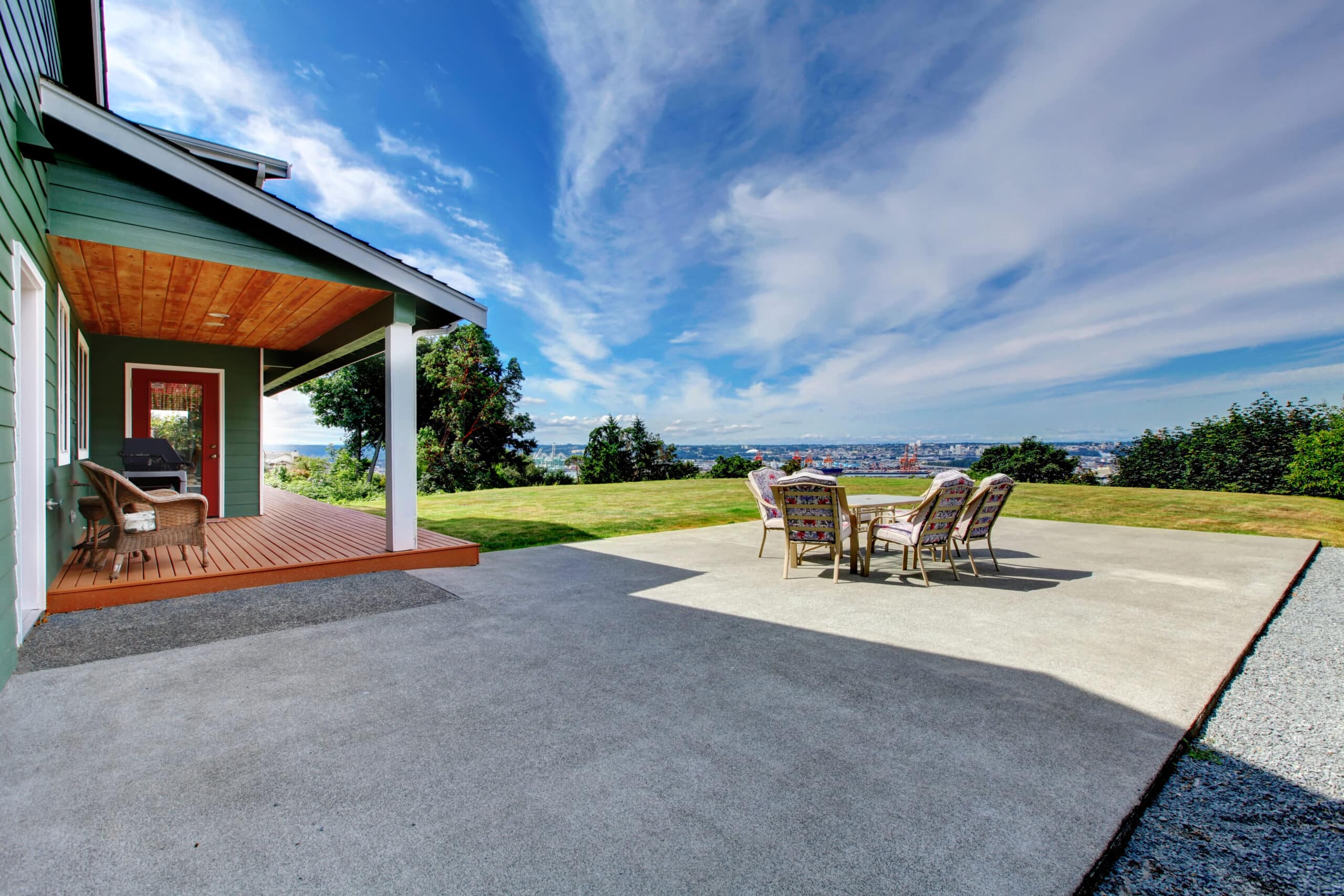 VIew of large concrete floor patio area with table set at backyard. Northwest, USA